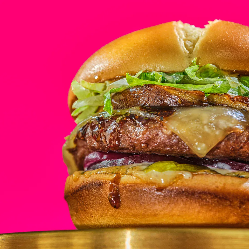 Red Robin burger close-up against a bright magenta background
